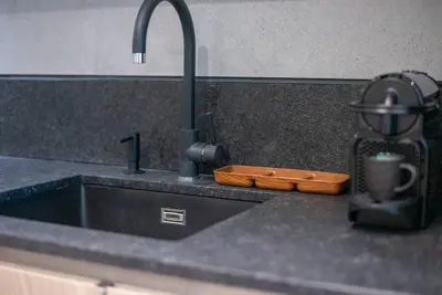 a kitchen counter top with a sink and a sink at Modern flat with KING SIZE bed and HIGH SPEED Wifi in Dubai