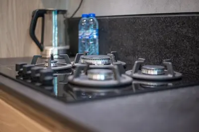 a stove top with a bottle of water on it at Modern flat with KING SIZE bed and HIGH SPEED Wifi in Dubai