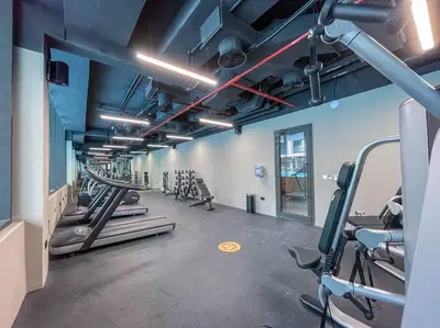 a gym with a row of treadmills and machines at Fantastic Studio resort style facilities - OFFER in Dubai