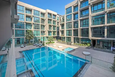 a swimming pool in front of a building at Fantastic Studio resort style facilities - OFFER in Dubai