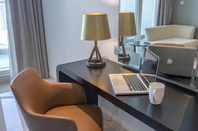 a hotel room with a desk with a laptop and chairs at Spectacular Burj Khalifa view service apartment in Dubai