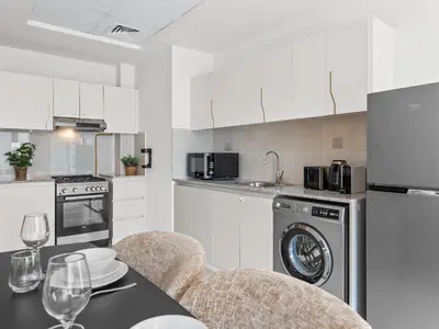 a kitchen with a table with two chairs and a dining room at Cozy Retreat 1Bedroom on the Business Bay Canal by Suiteable Interiors in Dubai