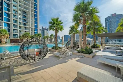 a park with swings and palm trees and a pool at At The Top Burj View STUDIO - Special offer in Dubai