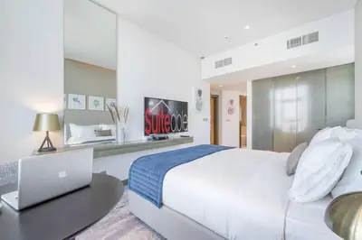 a bedroom with a bed and a desk with a laptop at At The Top Burj View STUDIO - Special offer in Dubai