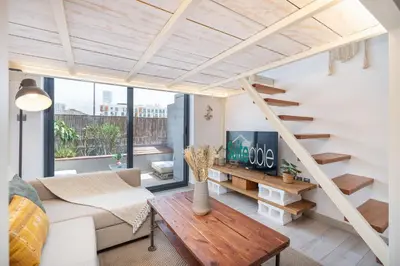 a living room with a staircase and a couch at Unique loft with smart working station in Dubai