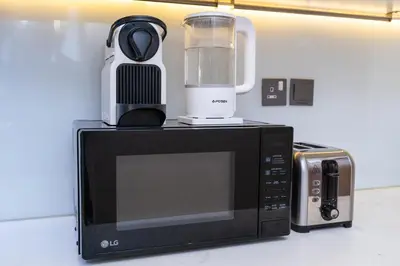 a blender sitting on top of a microwave at Unique loft with smart working station in Dubai