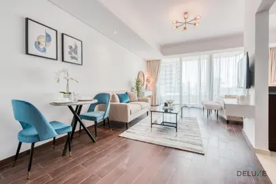 a living room with a couch and a table and chairs at Cozy Studio at The Matrix Sports City by Deluxe Holiday Homes in Dubai