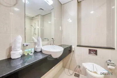 a bathroom with a sink and a mirror at Cozy Studio at The Matrix Sports City by Deluxe Holiday Homes in Dubai