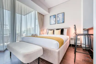 a bedroom with a large bed and a large window at Cozy Studio at The Matrix Sports City by Deluxe Holiday Homes in Dubai