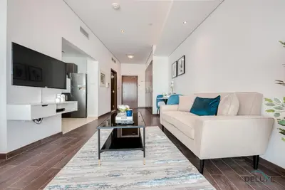 a living room with a couch and a table at Cozy Studio at The Matrix Sports City by Deluxe Holiday Homes in Dubai