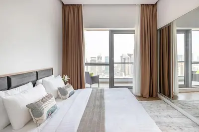 a bedroom with a large white bed and large windows at Frank Porter - Bay Central Tower 1 in Dubai