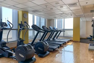a gym with rows of tread machines in a room at Frank Porter - Bay Central Tower 1 in Dubai