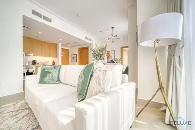 a living room with a white couch with green pillows at Extravagant 1BR at Opera Grand Downtown Dubai by Deluxe Holiday Homes in Dubai