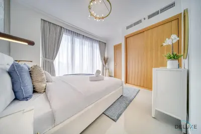 a white bedroom with a large bed and a window at Extravagant 1BR at Opera Grand Downtown Dubai by Deluxe Holiday Homes in Dubai