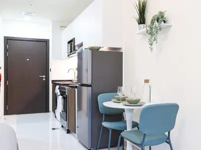 a kitchen with a small table and blue chairs at Elite LUX Holiday Homes - Modern Style Studio Superior Facilities in Arjan Dubai in Dubai