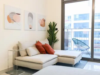 a living room with a couch and a chair at Elite LUX Holiday Homes - Modern Style Studio Superior Facilities in Arjan Dubai in Dubai