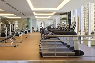 a gym with a row of cardio machines at Daniels 1BR at JW Marriott with Dubai Marina View in Dubai