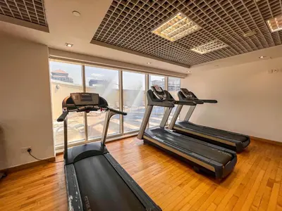 a gym with three treadmills in a room at Cosmos Living Modern Studio Near Dubai Marina in Dubai