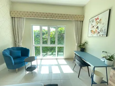 a living room with a blue table and a blue chair at Discovery Gardens Haven Studios in Dubai