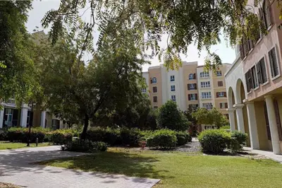 a building with a tree in the middle of a yard at Discovery Gardens Haven Studios in Dubai