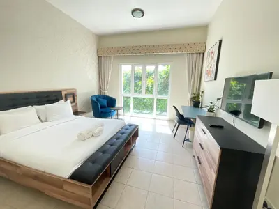 a bedroom with a large bed and a desk and chair at Discovery Gardens Haven Studios in Dubai
