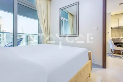 a bedroom with a bed and a large window at Staycae Holiday Homes - Reva in Dubai