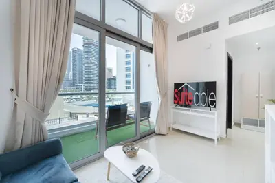 a living room with a couch and a large window at Classic Studio With Dubai Marina View in Dubai