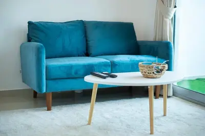 a blue couch and a coffee table in a living room at Classic Studio With Dubai Marina View in Dubai