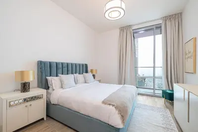 a bedroom with a large bed and a large window at Noora Tower I Spacious 3BDR Apartment and maid room with Burj Khalifa View in Dubai