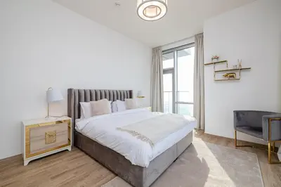 a white bedroom with a large bed and a window at Noora Tower I Spacious 3BDR Apartment and maid room with Burj Khalifa View in Dubai