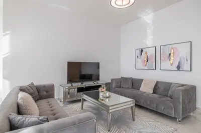 a living room with two couches and a tv at Noora Tower I Spacious 3BDR Apartment and maid room with Burj Khalifa View in Dubai