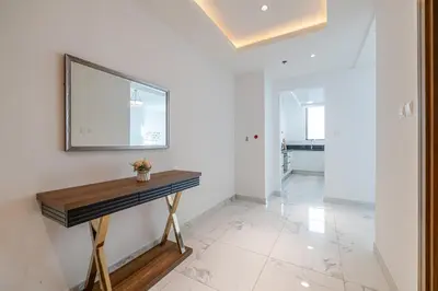 a room with a table and a mirror on the wall at Noora Tower I Spacious 3BDR Apartment and maid room with Burj Khalifa View in Dubai