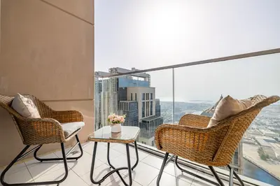 a balcony with two chairs and a table with a view at Noora Tower I Spacious 3BDR Apartment and maid room with Burj Khalifa View in Dubai