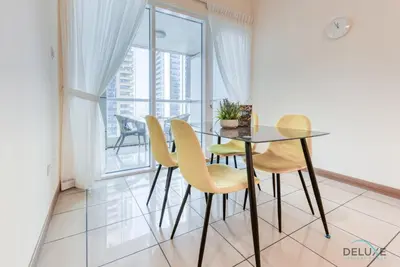 a dining room with a table and chairs and a balcony at Bright 1BR at Sulafa Tower Dubai Marina by Deluxe Holiday Homes in Dubai