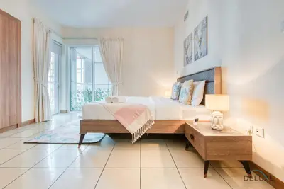 a bedroom with a large bed and a table at Bright 1BR at Sulafa Tower Dubai Marina by Deluxe Holiday Homes in Dubai