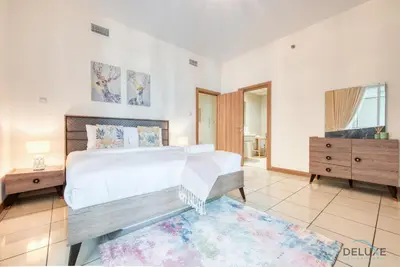 a bedroom with a large bed and a dresser at Bright 1BR at Sulafa Tower Dubai Marina by Deluxe Holiday Homes in Dubai