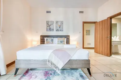 a bedroom with a large bed with white sheets at Bright 1BR at Sulafa Tower Dubai Marina by Deluxe Holiday Homes in Dubai