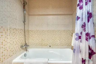 a bath tub in a tiled bathroom with a shower curtain at Bright 1BR at Sulafa Tower Dubai Marina by Deluxe Holiday Homes in Dubai