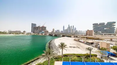 a body of water with palm trees and a bridge at Hashtag Holiday Home - Luxury 2BDR Apartment on The Palm Azure Residences in Dubai