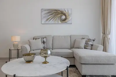 a living room with a couch and a table at Close To Metro with Frame View in Dubai