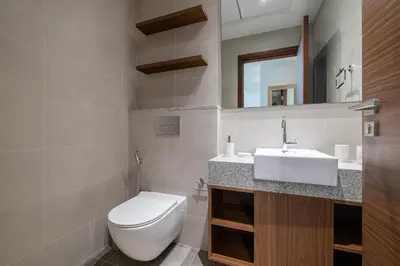 a bathroom with a white toilet and a sink at Close To Metro with Frame View in Dubai