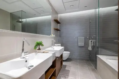a bathroom with two sinks and a toilet and a shower at Close To Metro with Frame View in Dubai