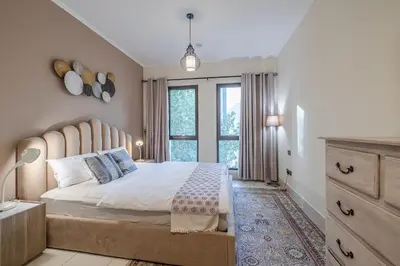 a bedroom with a large bed with a large window at 1 Bedroom at Yansoon 4, Downtown Old Town with Garden View in Dubai