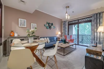 a living room with a table and chairs and a couch at 1 Bedroom at Yansoon 4, Downtown Old Town with Garden View in Dubai