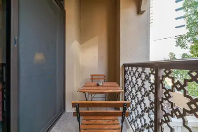 a wooden table and bench on a balcony at 1 Bedroom at Yansoon 4, Downtown Old Town with Garden View in Dubai