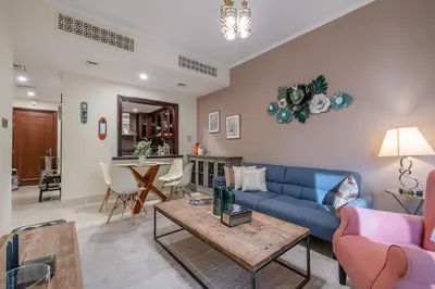 a living room with a blue couch and a table at 1 Bedroom at Yansoon 4, Downtown Old Town with Garden View in Dubai
