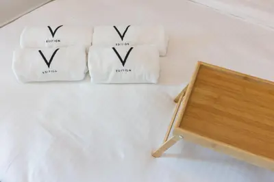 two towels on a bed next to a wooden table at Spacious 1BR with full Marina View in Dubai