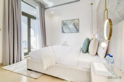 a white living room with a white couch and a table at Signature 6BR Villa with Assistant Room and Private Pool in Frond F Palm Jumeirah by Deluxe Holiday Homes in Dubai