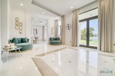a living room with blue furniture and a large window at Signature 6BR Villa with Assistant Room and Private Pool in Frond F Palm Jumeirah by Deluxe Holiday Homes in Dubai
