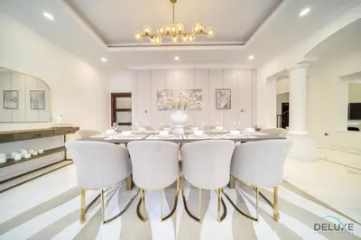 a dining room with a table and chairs at Signature 6BR Villa with Assistant Room and Private Pool in Frond F Palm Jumeirah by Deluxe Holiday Homes in Dubai
